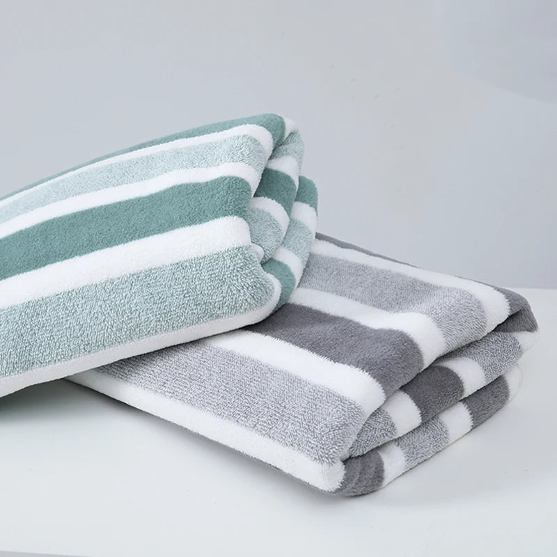 Soft and absorbent striped bath towels, featuring a green towel with white stripes and a gray towel with white stripes. Made from a durable polyester/cotton blend, these towels are perfect for bathrooms, offering quick-drying material and a stylish design for everyday use.