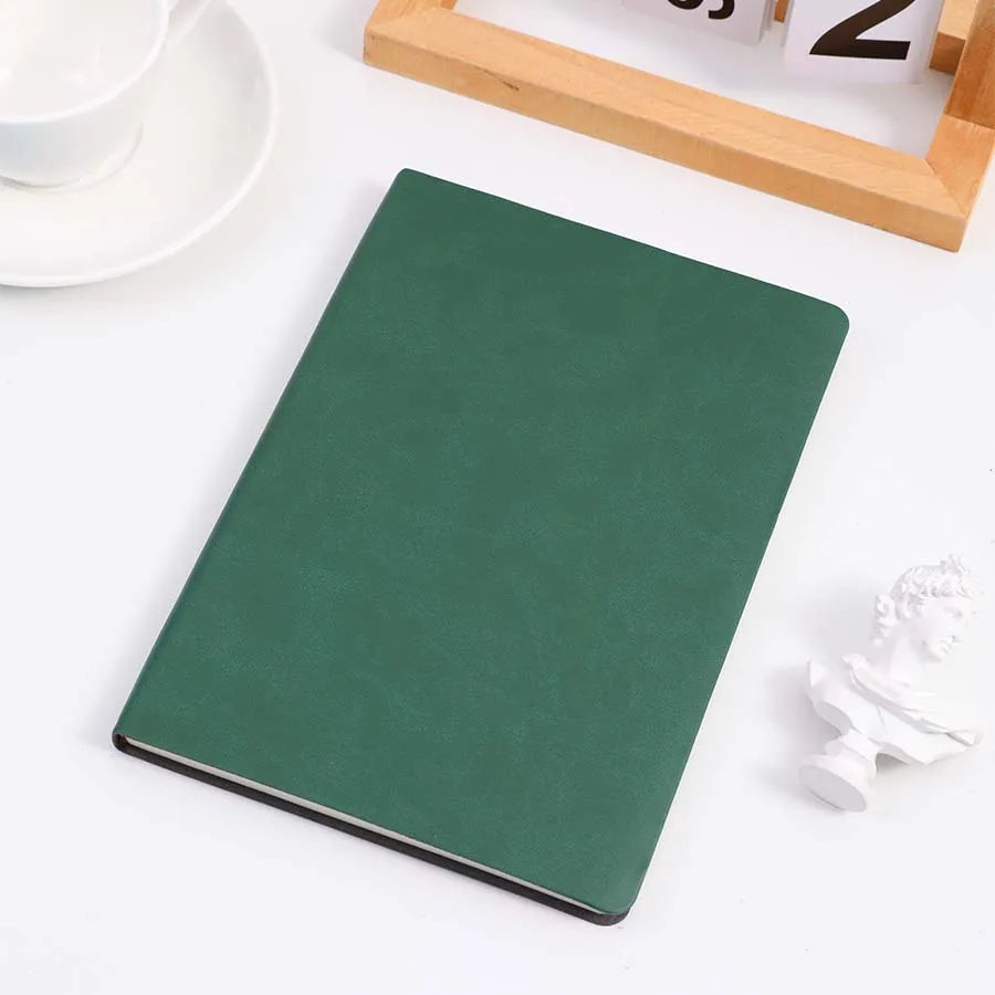 Green cover notebook placed on a table, perfect for note-taking, journaling, and diaries. Features a sleek and minimalist design.