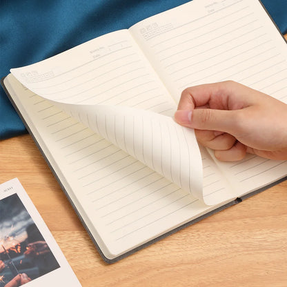 Hand flipping pages of a notebook with lined paper, ideal for note-taking, journaling, and diaries. Features a minimalist design with options for leather covers.