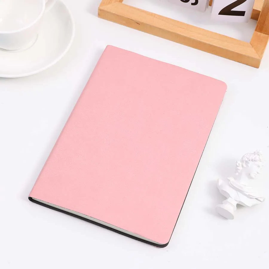 Pink cover notebook placed on a table, perfect for note-taking, journaling, and diaries. Features a sleek and minimalist design.