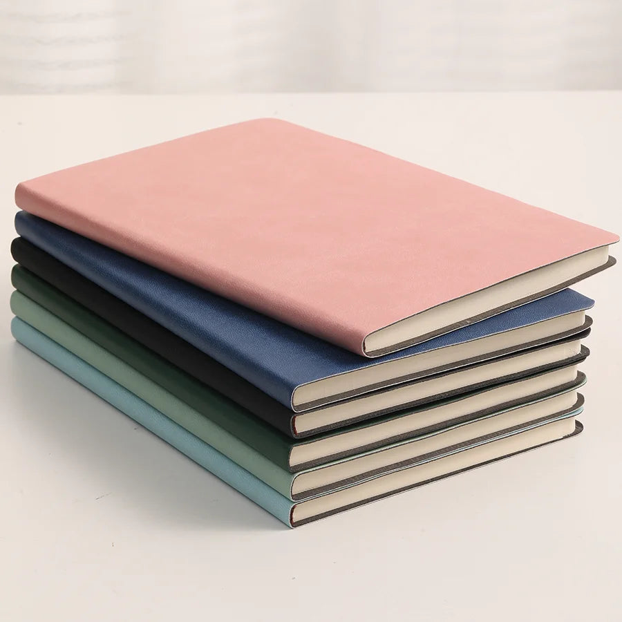 Stack of six vibrant notebooks in assorted colors, featuring a sleek, minimalist design. Ideal for note-taking, journaling, or keeping diaries. Some include a leather cover for added style and durability.